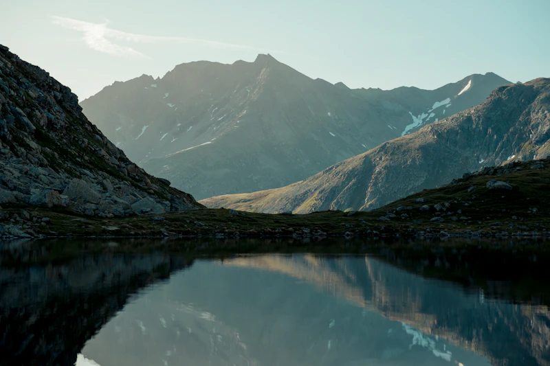 A still Swiss lake reflecting the surrounding mountains